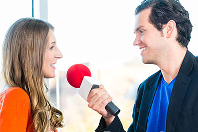 Man interviewing a woman with a microphone